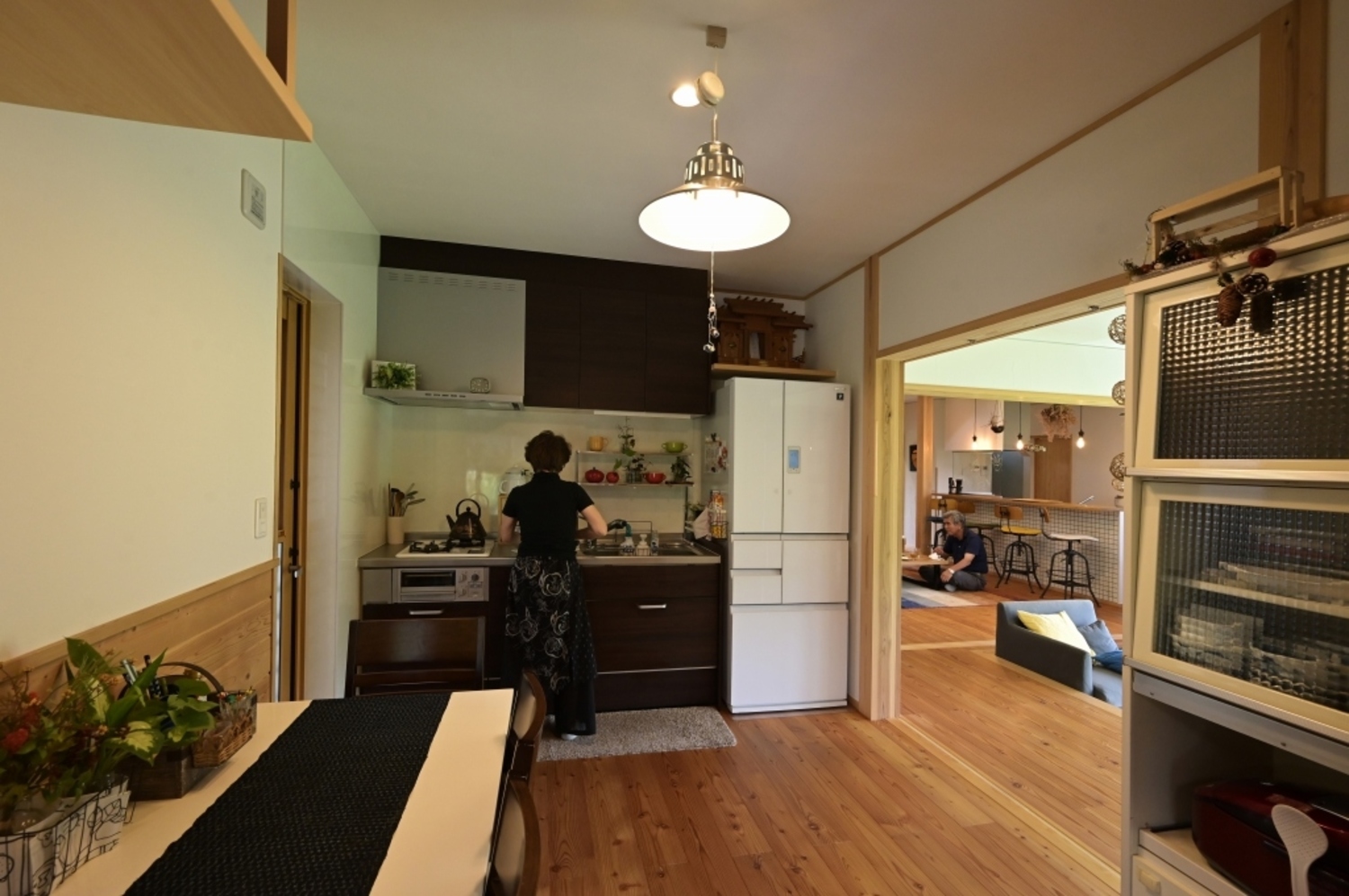 親世帯は落ち着いて作業できる壁付けキッチン。障子戸をオープンにすると、共有の土間サロンにつながる。