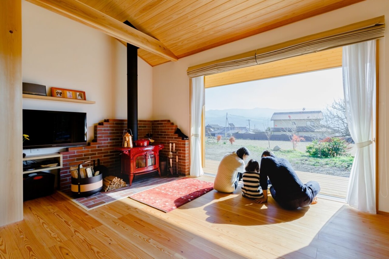 フルオープンサッシを介して、リビングからウッドデッキ、さらに屋外へと空間が広がる、気持ちまで開放されるような伸びやかな空間。