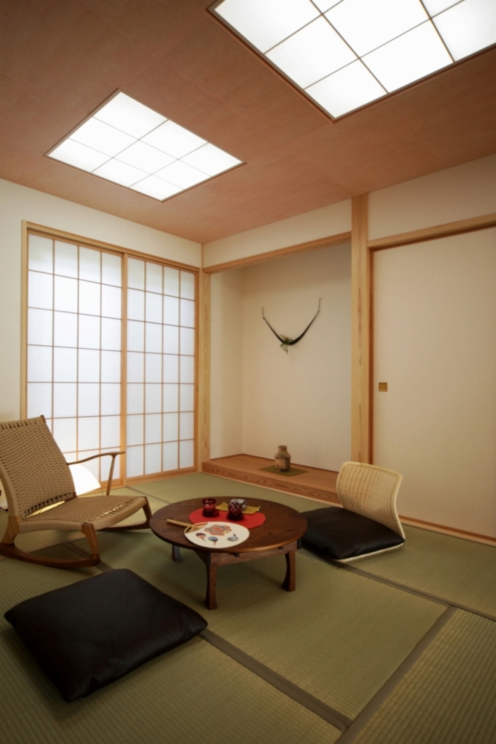 桜色の彩色和紙の天井が明るい印象の和室。障子戸を開くと中庭を望める。