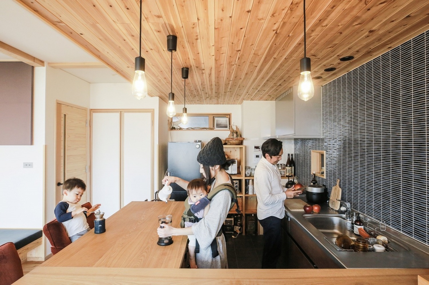壁付けキッチン。後ろを振り向けばカウンターテーブルなので、作業や配膳がしやすい。壁のタイルもアクセントになり、空間を引き締めている。