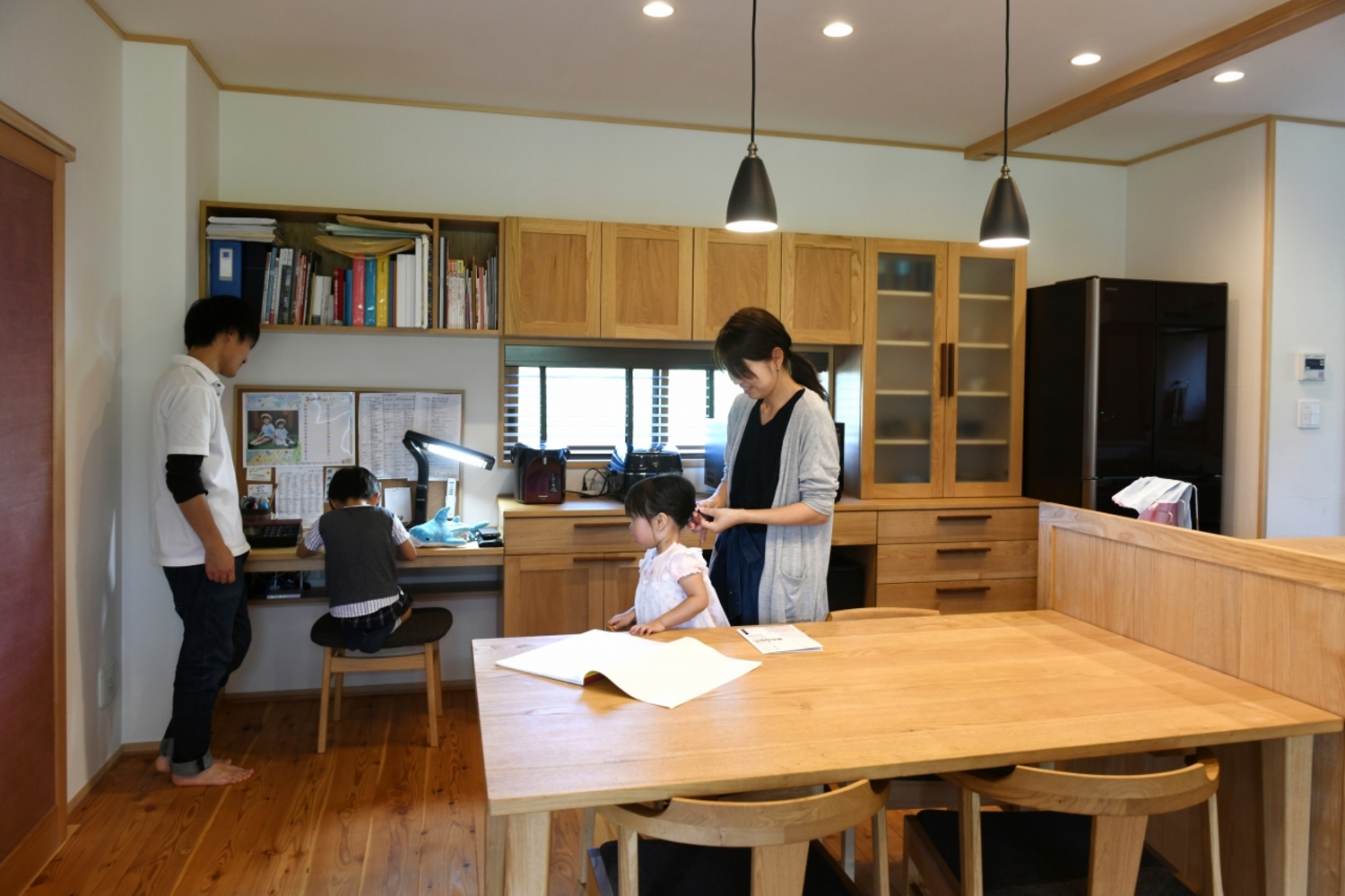 キッチン背面収納は木製で造りつけた。続きで勉強コーナーも設け、親子がいつも一緒にいられる。