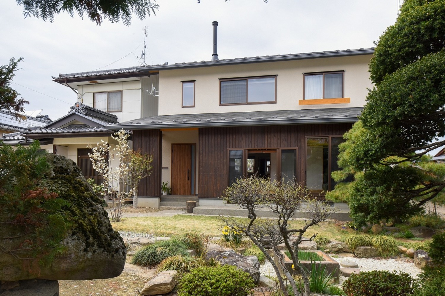 母屋の一部を解体し、横並びに新築。落ち着いた外観デザインが周囲の建物や歴史ある庭と調和する。
