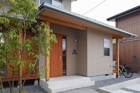 玄関ドアは木製の造作ドア。温もりある佇まいが家族を出迎える。