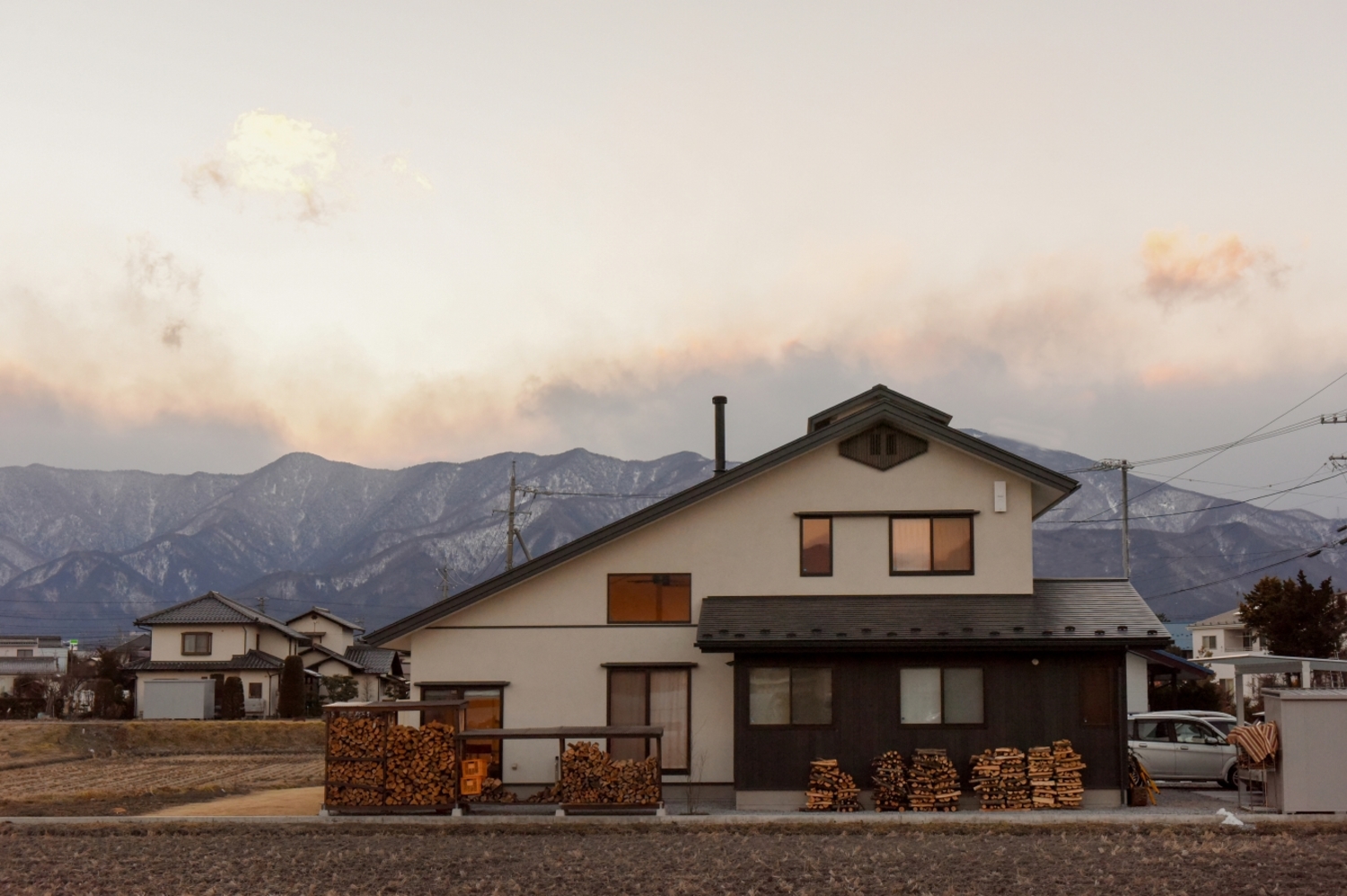 北アルプスの山並みに沿う、南に葺き下ろした大屋根の外観。黒のアクセントカラーで和モダンの趣に。