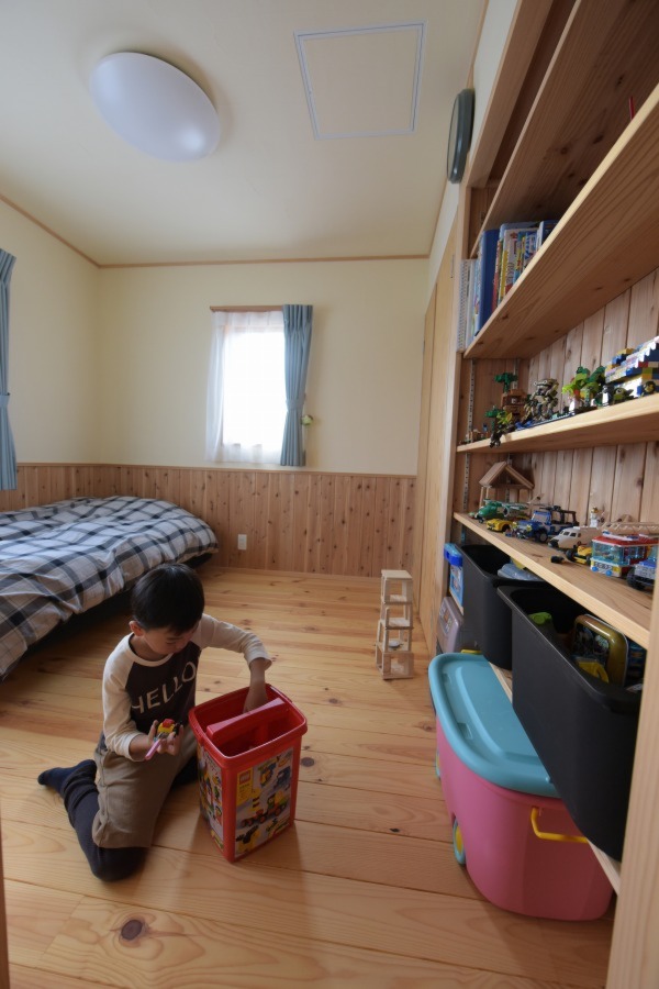 息子さんのお部屋。床材は長野県産の赤松。造り付けの本棚には教科書と彼のお気に入りのオモチャが飾られている。