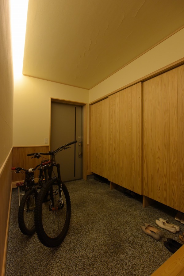 ５畳の広さを確保した玄関。広く設けた土間には趣味のマウンテンバイクを。壁一面の収納には、家族５人の靴がたっぷり置ける。