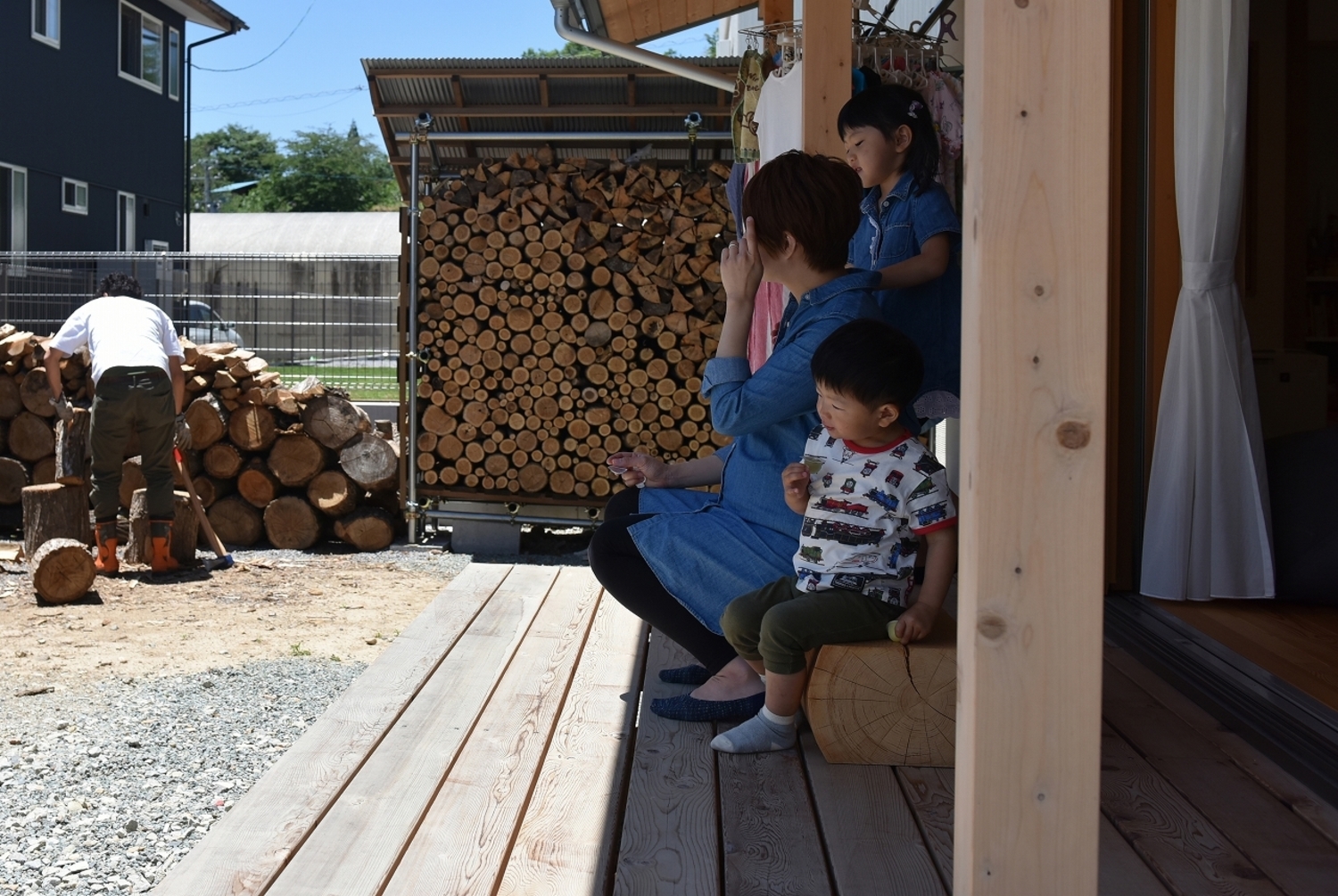 薪作業をするご主人様の隣で、奥様は庭の手入れをしたり、子供たちは砂利遊びをしたり。ちょっと疲れたらウッドデッキでお茶や、時にはランチも。外とつながる暮らしを存分に楽しむ。