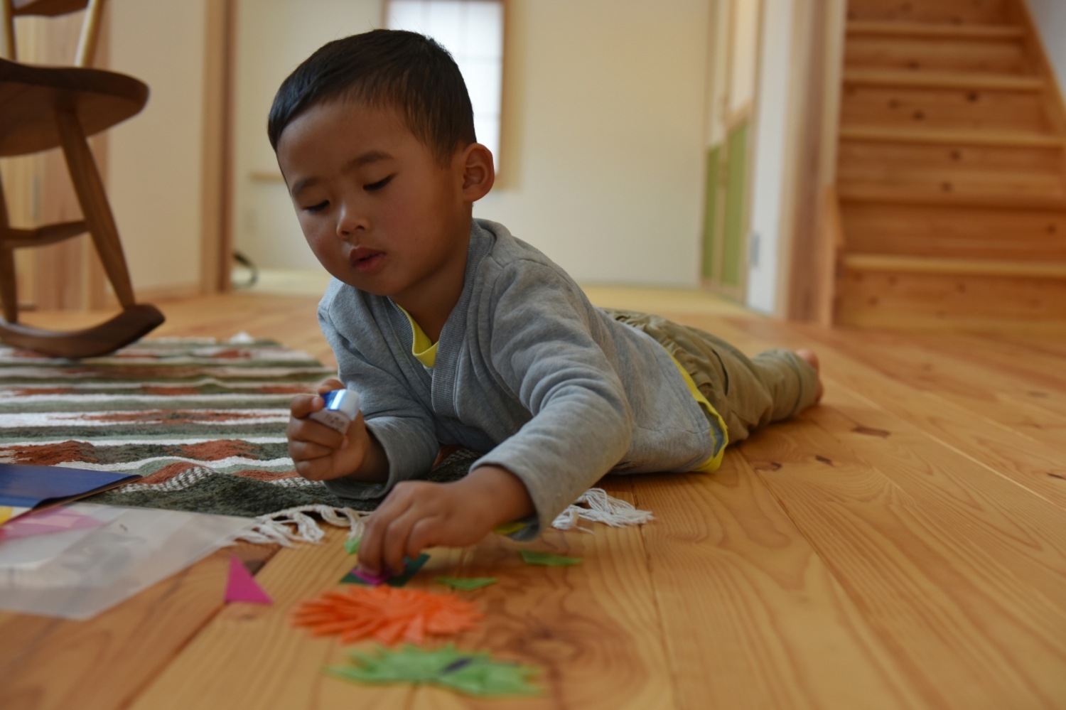 冬でも赤松の床にごろりと寝転んであそぶ。無垢の木肌が薪ストーブのぬくもりを含み、なんとも心地よい。