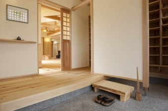 住まいの顔となる玄関はしつらえにもこだわり、季節に合わせて飾り変えられるピクチャーレールと飾り棚を設けた。目隠し壁の向こうに下足入れを設け、見た目にもすっきりと。